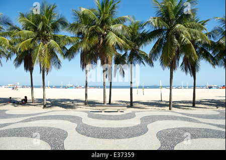 Kultige geschwungene Bürgersteig Fliesenmuster mit Palmen am Copacabana Strand Rio de Janeiro Brasilien Stockfoto