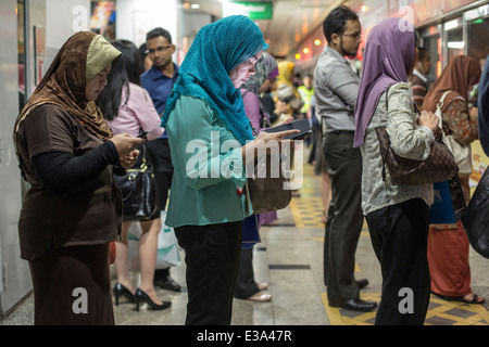 Pendler warten auf einen Zug an einer RapidKL LRT Station in Kuala Lumpur, Malaysia Stockfoto