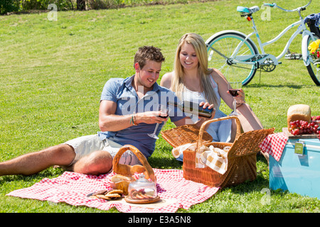 Ein junges Paar teilt einen glücklichen Moment Picknick auf dem Rasen auf dem Lande Stockfoto