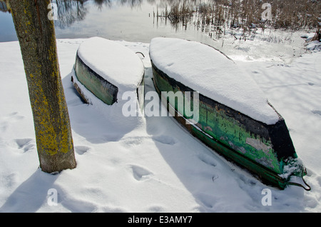 zwei Winter Zeit alte Holzboote auf Schnee in der Nähe von Fluss Stockfoto