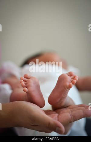 Baby Kleinkind kostbare Füße über Mutters Hand - Unschuld-Konzept Stockfoto