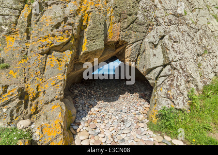 KIESELSTEINE IN EINEM TORBOGEN ZUM MEER GEFUNDEN IN KLIPPEN IN DER NÄHE VON HOPEMAN AM SCHOTTISCHEN MORAY COAST TRAIL Stockfoto