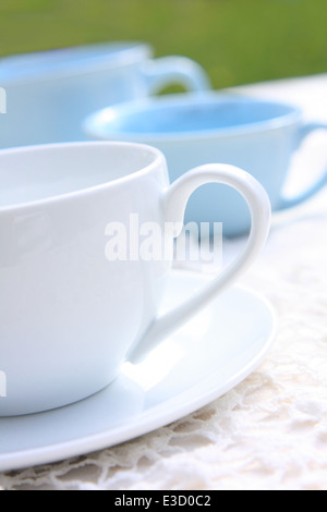 Blaue und weiße Teetassen auf dem Tisch gedeckt mit Spitzen Tischdecke Stockfoto