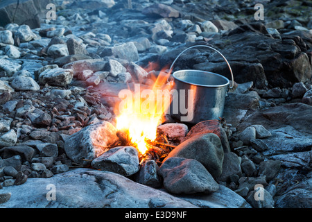 Lagerfeuer an einem steinigen Strand bei Abenddämmerung England UK Stockfoto