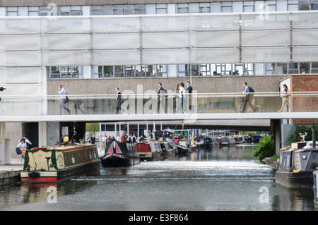 Arbeiter eilen zu/von der Arbeit, während Menschen in Hausboote auf dem Fluss bei Paddington Becken entspannen Stockfoto