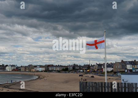 Das St George Flagge am Strand Newbiggin am Meer an einem bewölkten Tag Stockfoto