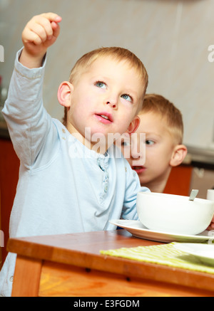 Glückliche Kindheit. Zwei blonde Brüder jungen Kids Kinder Cornflakes Essen Frühstück Frühstück am Tisch. Zu Hause. Stockfoto