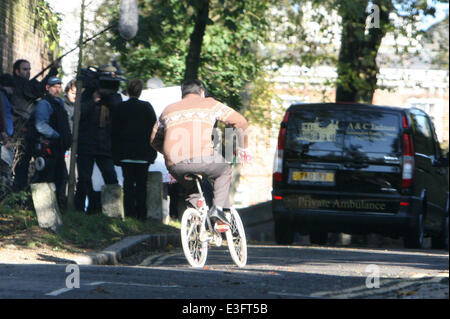 Ricky Gervais die Dreharbeiten für die neue Channel 4 TV-Serie "Derek" in Nord-London. Gervais' Body-double sieht man gefilmt Reiten ein Mädchen Fahrrad jagen einen Bestattungsunternehmen van mehrmals, bevor Gervais Kontrolle über das Fahrrad Mädchen nahm.  Mitwirkende: Ricky Gervais Stockfoto