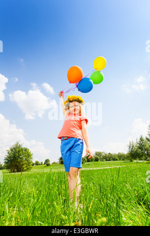 Kleines Mädchen mit bunten Luftballons tragen reif Stockfoto