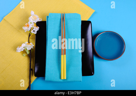 Moderne Interpretation der traditionellen japanischen orientalische Gedeck mit bunten Stäbchen und gelb und Aqua blue colour-blocking. Stockfoto