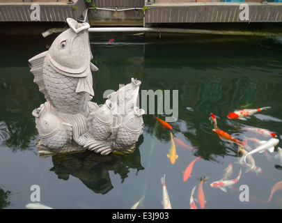 Stein Schnitzen von Koi-Karpfen im Teich Stockfoto