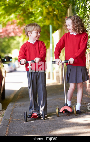 Jungen und Mädchen Motorroller auf dem Weg zur Schule Stockfoto