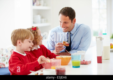 Vater und Kinder frühstücken In der Küche zusammen Stockfoto