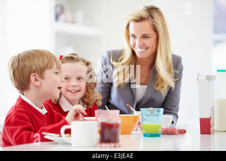 Mutter und Kinder frühstücken In der Küche zusammen Stockfoto