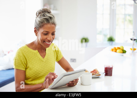 Afrikanische amerikanische Frau, die mit Digital-Tablette zu Hause Stockfoto
