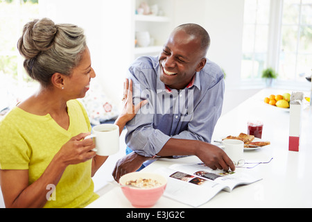 Paar beim Frühstück und lesen In Küche Stockfoto