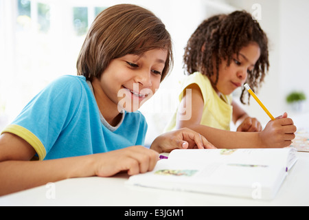 Kinder, die Hausaufgaben In der Küche zusammen Stockfoto