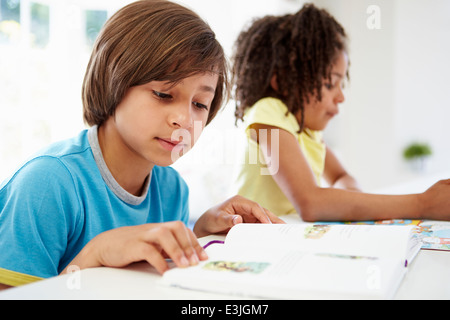 Kinder, die Hausaufgaben In der Küche zusammen Stockfoto