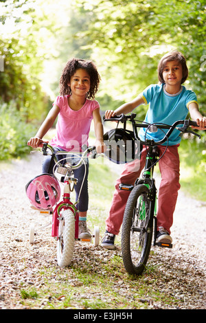 Zwei Kinder auf Zyklus fahren auf Land Stockfoto