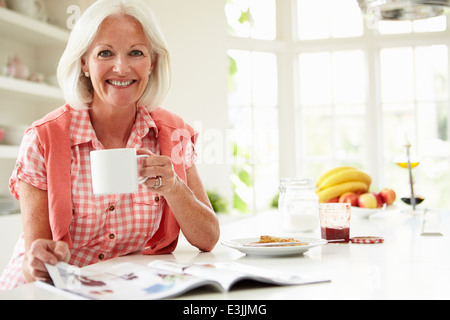 Applying Magazin Woman lesen beim Frühstück Stockfoto