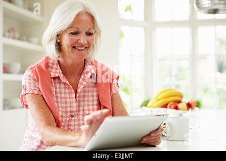 Applying Frau mit Digital-Tablette über Frühstück Stockfoto