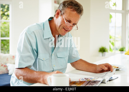 Applying Mann Lesung Magazin beim Frühstück Stockfoto