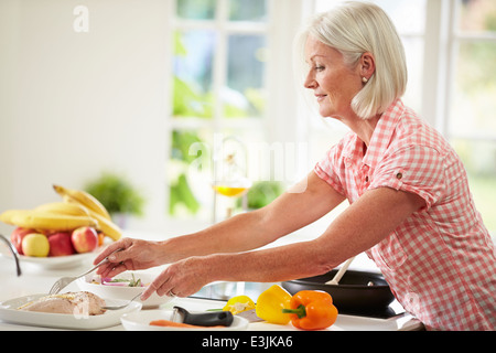 Applying Frau Kochen Mahlzeit In der Küche Stockfoto