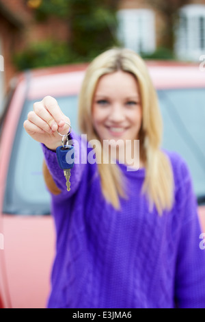 Teenager-Mädchen stehen neben Auto-Taste gedrückt halten Stockfoto