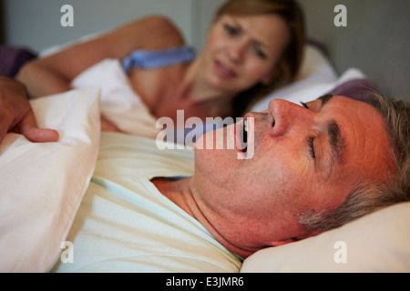 Mann Frau mit Schnarchen wach im Bett zu halten Stockfoto