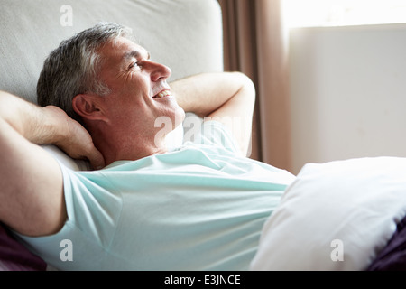 Im mittleren Alter Mann aufwachen im Bett Stockfoto