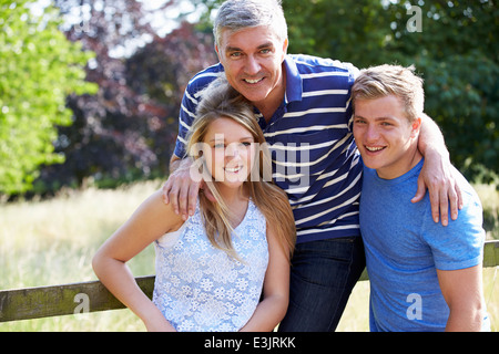 Vater mit Kindern im Teenageralter zu Fuß auf Land Stockfoto