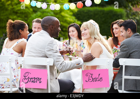 Braut und Bräutigam genießen Mahlzeit bei Hochzeitsfeier Stockfoto