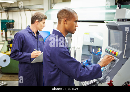 Ingenieur und Lehrling mit automatisierten Fräsmaschine Stockfoto