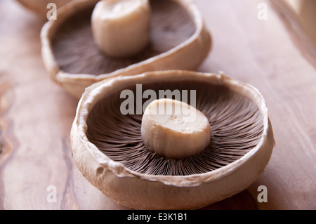 Drei Portobello Pilze auf einem rustikalen Schneidebrett Stockfoto