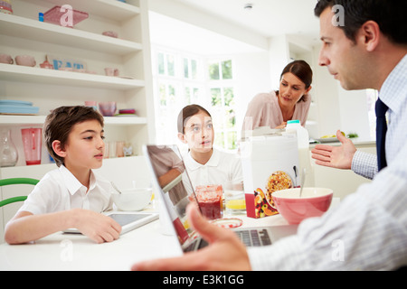 Familie mit Hilfe von digitalen Geräten mit Argument beim Frühstück Stockfoto