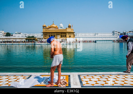 Sikh-Pilger abtrocknen nach dem Baden im Heiligen Tank rund um den goldenen Tempel in Amritsar, Indien Stockfoto