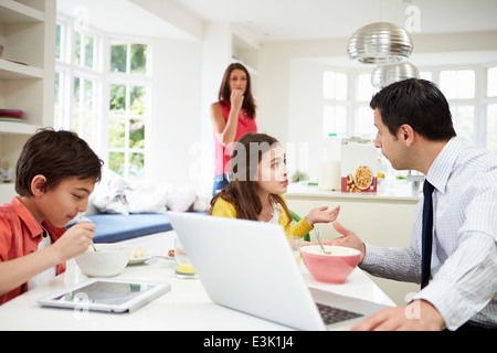 Familie mit Hilfe von digitalen Geräten mit Argument beim Frühstück Stockfoto