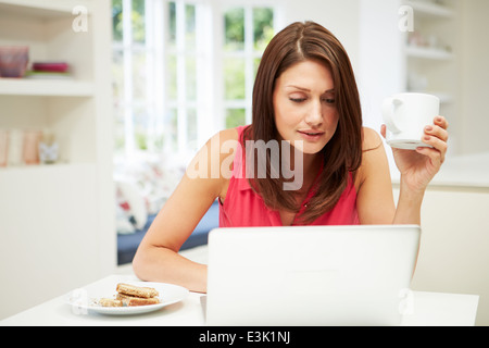 Hispanic Frau mit Laptop In der Küche zu Hause Stockfoto