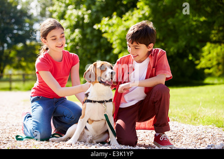 Hispanischen Kinder mit Hund für Spaziergang In Natur Stockfoto