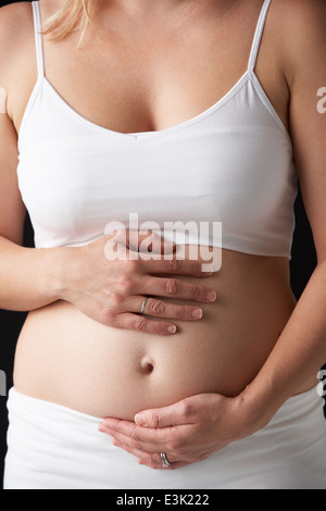 Close Up Portrait der schwangeren Frau auf schwarzem Hintergrund Stockfoto