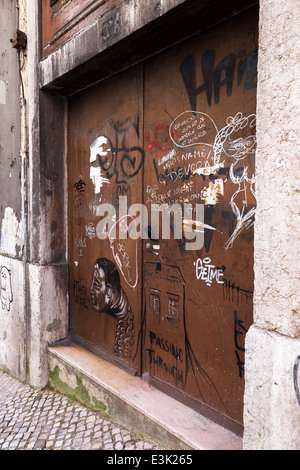 Graffiti auf eine braune Paited hölzerne Tür Lissabon Portugal. Stockfoto