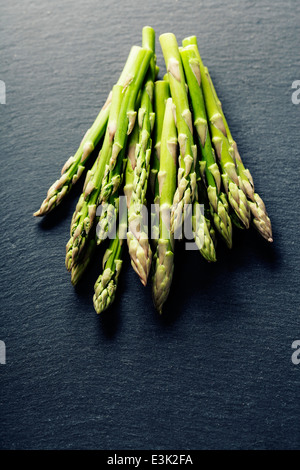 Reihe von frischem Spargel auf Schiefer Hintergrund Stockfoto