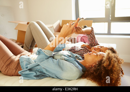 Zwei Frauen, Umzug in neues Zuhause mit digitalen Tablet Stockfoto