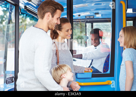 Familie einsteigen in Bus und Ticket kaufen Stockfoto