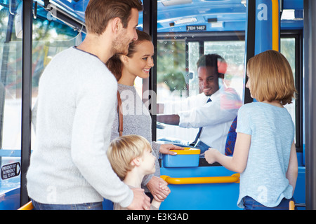 Familie einsteigen in Bus und Ticket kaufen Stockfoto