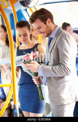 Mann geht bis heute auf Bus hält Blumenstrauß Stockfoto