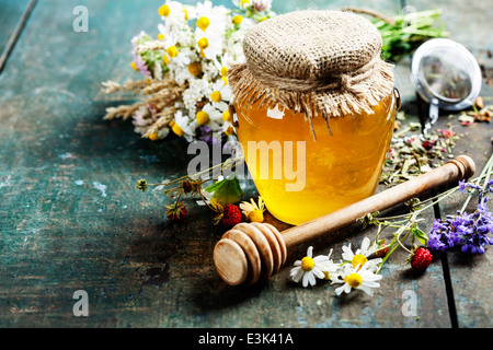 Honig und Kräutertee auf hölzernen Hintergrund - Sommer, Gesundheit und Bio-Lebensmittel-Konzept Stockfoto