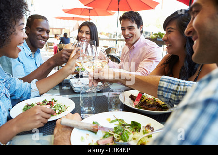 Gruppe von Freunden genießen Mahlzeit im Restaurant unter freiem Himmel Stockfoto