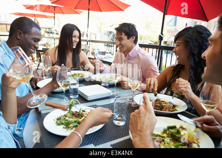 Gruppe von Freunden genießen Mahlzeit im Restaurant unter freiem Himmel Stockfoto