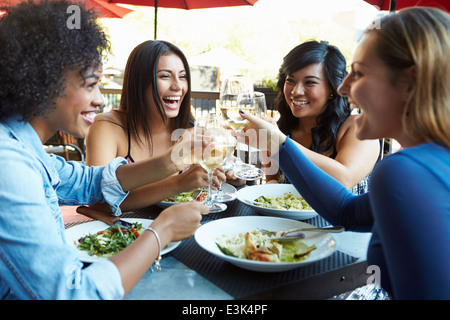 Gruppe von Freundinnen genießen Mahlzeit im Restaurant unter freiem Himmel Stockfoto